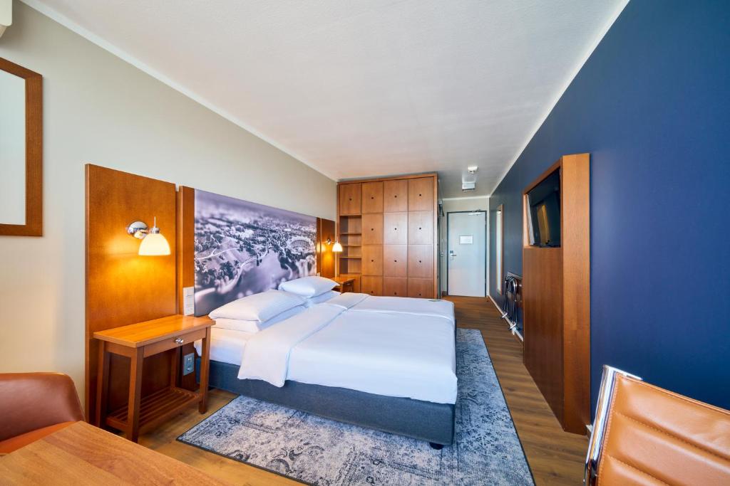 慕尼黑奥林匹亚公园安娜艺术酒店的卧室配有一张白色的大床和一张沙发。