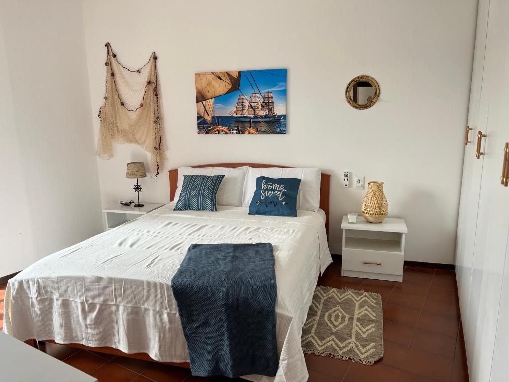 锡尔维玛丽娜Beach apartments Spiaggia Nascosta的卧室配有带蓝色枕头的大型白色床