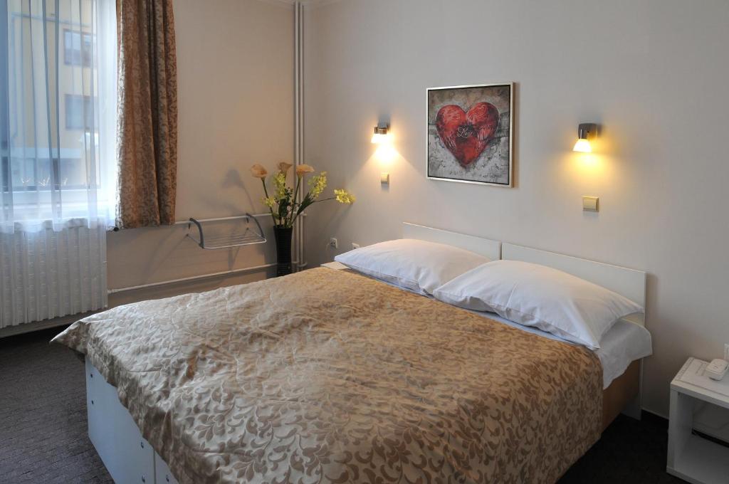 布拉格威尔海姆酒店的卧室配有一张墙上红色心的床铺