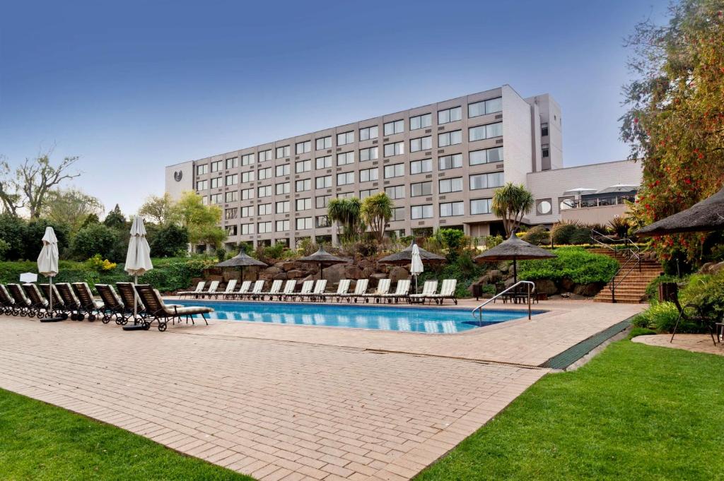 范德拜尔帕克Riverside Sun的一座带游泳池和椅子的酒店和一座建筑
