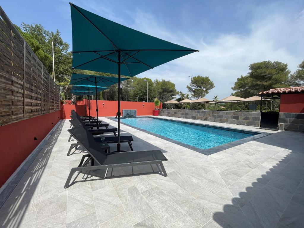 穆昂萨尔图Urban Style Cannes Mouans-Sartoux - Piscine Extérieure - Parking Gratuit的一个带躺椅和大遮阳伞的游泳池
