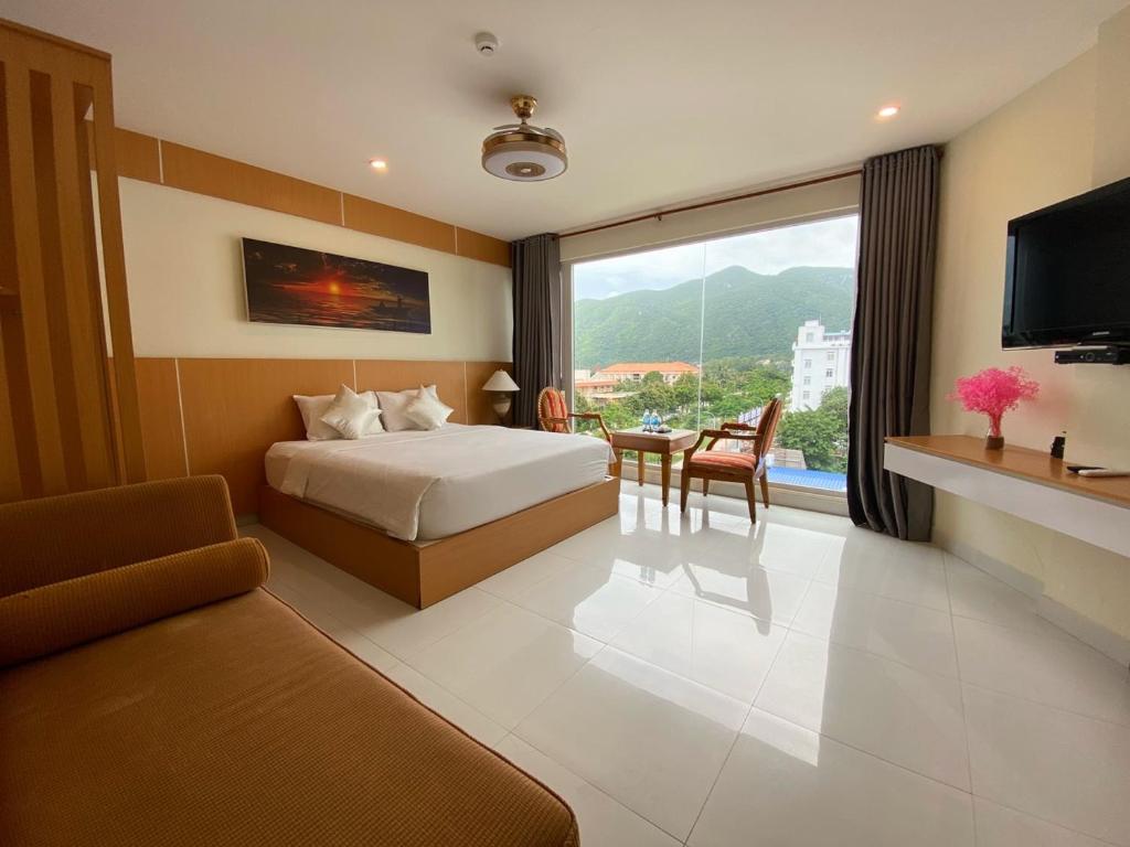 昆岛Conson Hotel的酒店客房配有1张床、1台电视和1张沙发。