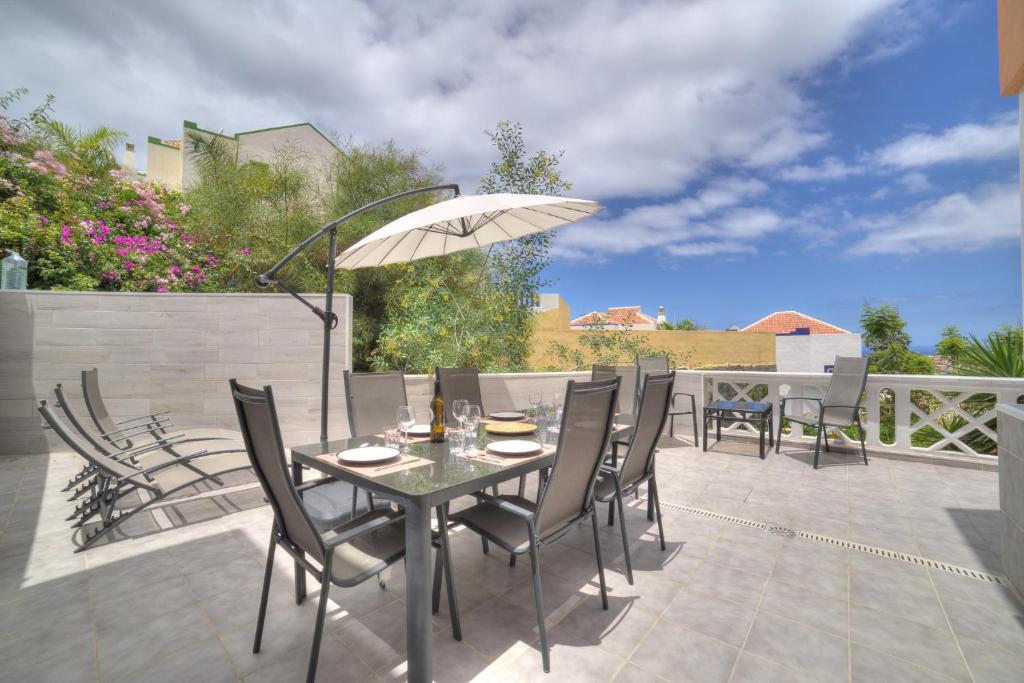 阿德耶Ocean Hill - Ocean View, Terrace, BBQ, WIFI的庭院配有桌椅和遮阳伞。