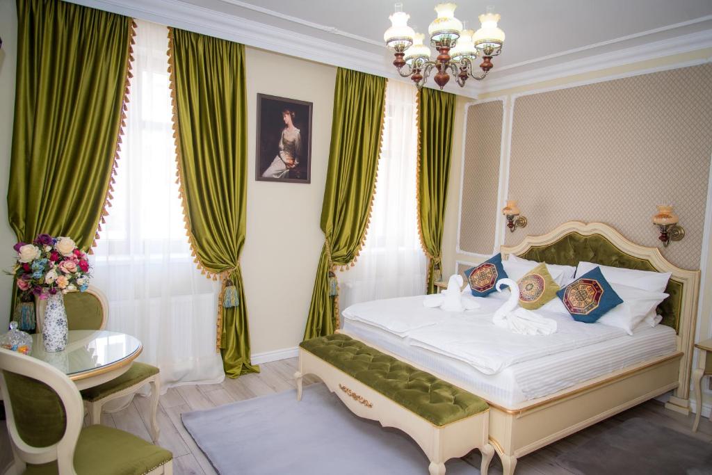 锡比乌Cochet House Sibiu的一间卧室配有一张带绿色窗帘和吊灯的床。