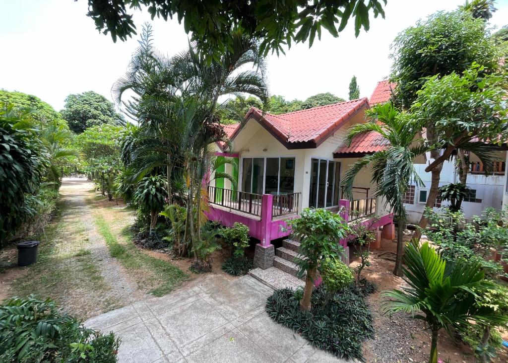 拉迈Mae Somboon House的花园中间的粉红色房子