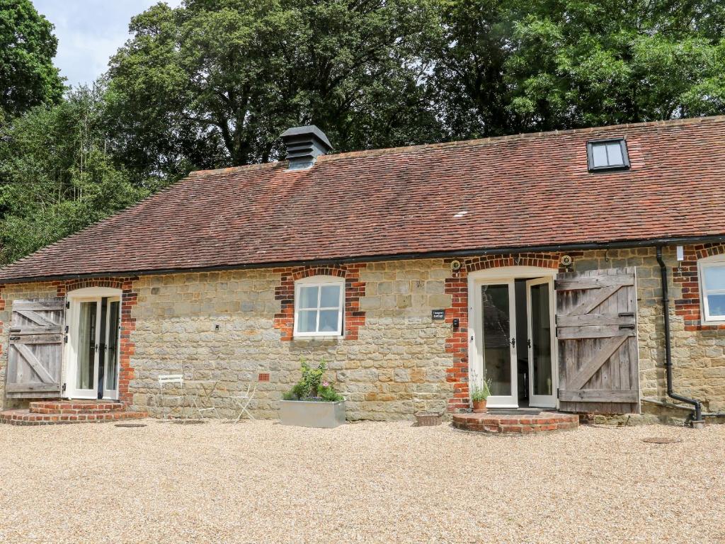 佩特沃斯Hungers Cottage的一个小砖屋,有窗户和屋顶