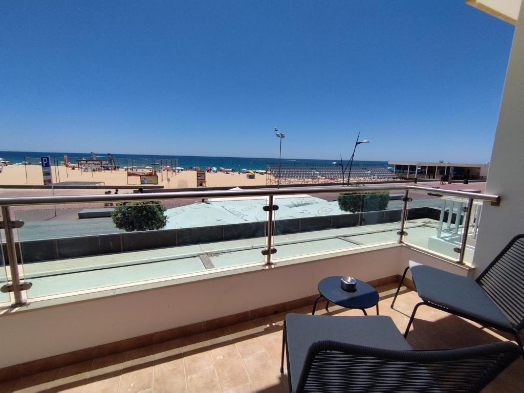 阿玛考德佩拉T2 - Praia Pescadores Frente Mar - Casas & Papéis的一个带椅子的阳台,享有海滩美景