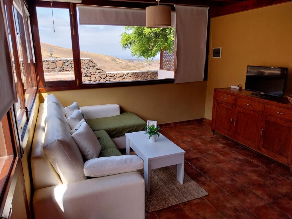亚伊萨Finca Esperanza的带沙发、电视和桌子的客厅