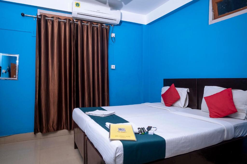 古瓦哈提Shree Krishna GH的蓝色的房间,床上写着一本书