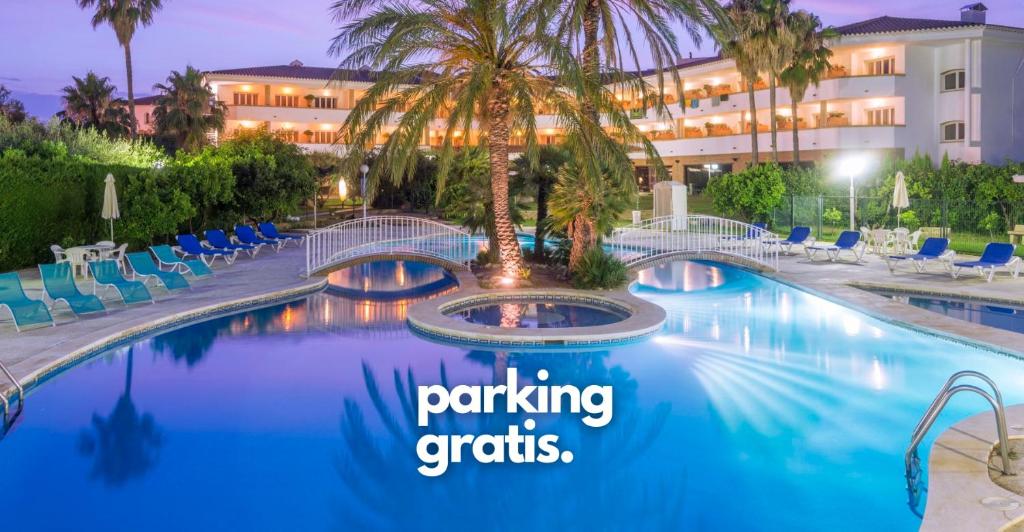 坎布里尔斯麦斯哥路酒店的一个带棕榈树的度假泳池和免费的单词停车场