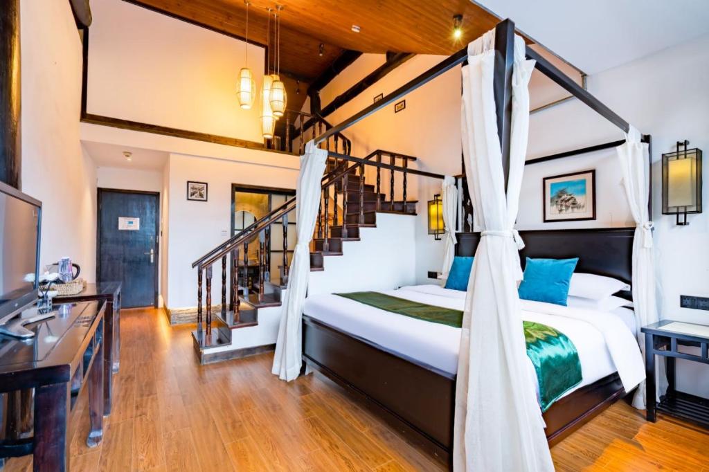苏州天易居客栈(苏州同里古镇店)的一间卧室设有一张床和一个楼梯