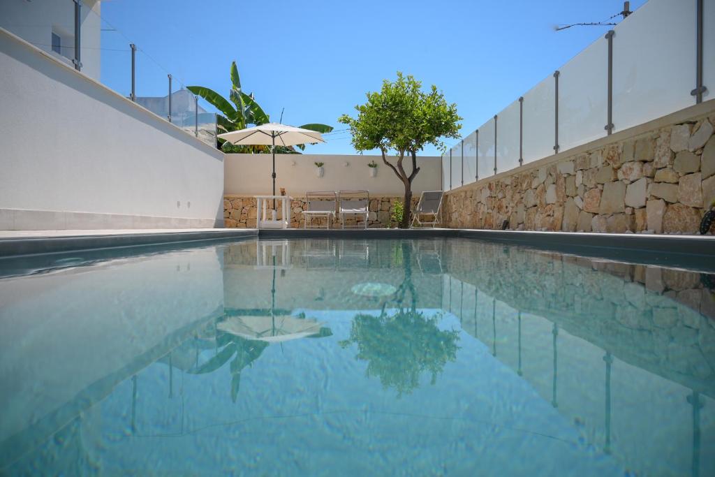 诺托玛丽娜Villa Carlotta con piscina的一座空的游泳池,里面配有遮阳伞