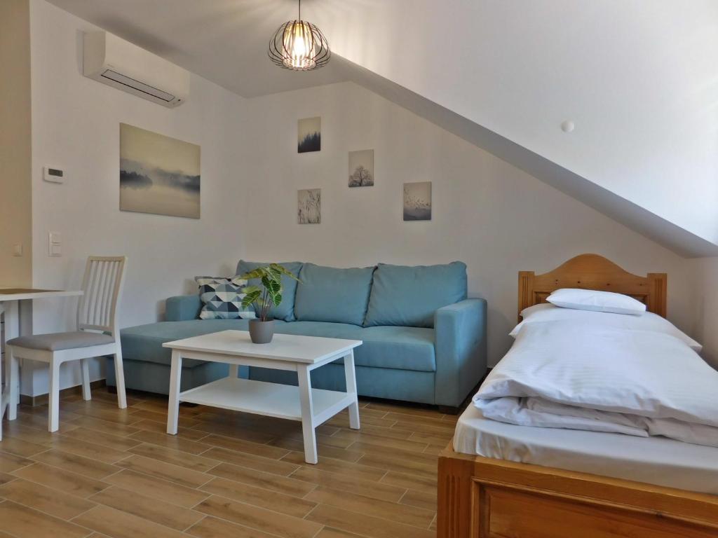 克尔门德Berki Apartman的客厅配有蓝色的沙发和桌子
