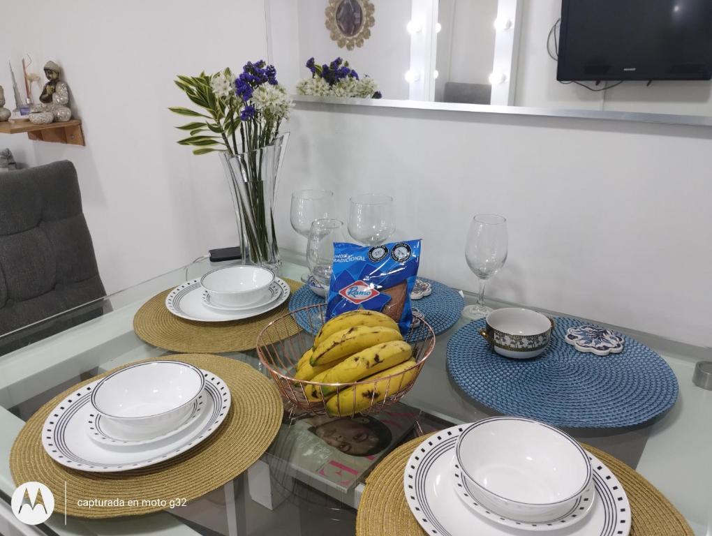 波哥大Apartamento sector exclusivo acogedor的一张桌子,上面放有盘子和一碗香蕉