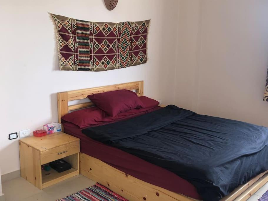 达哈布Dahab Relax Studio 3的一间卧室配有一张木床、床头柜和一张四柱床