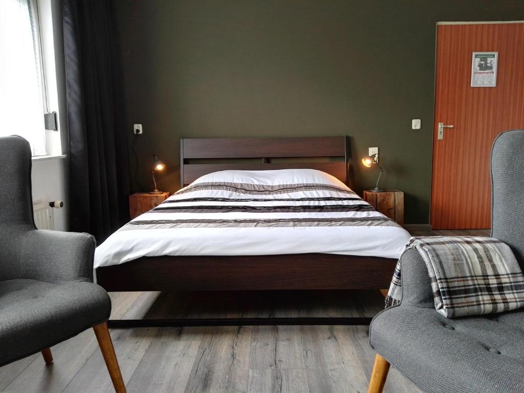 塞罗斯凯尔克Bed & Breakfast Carpe Diem Zeeland的一间卧室配有一张大床和两把椅子