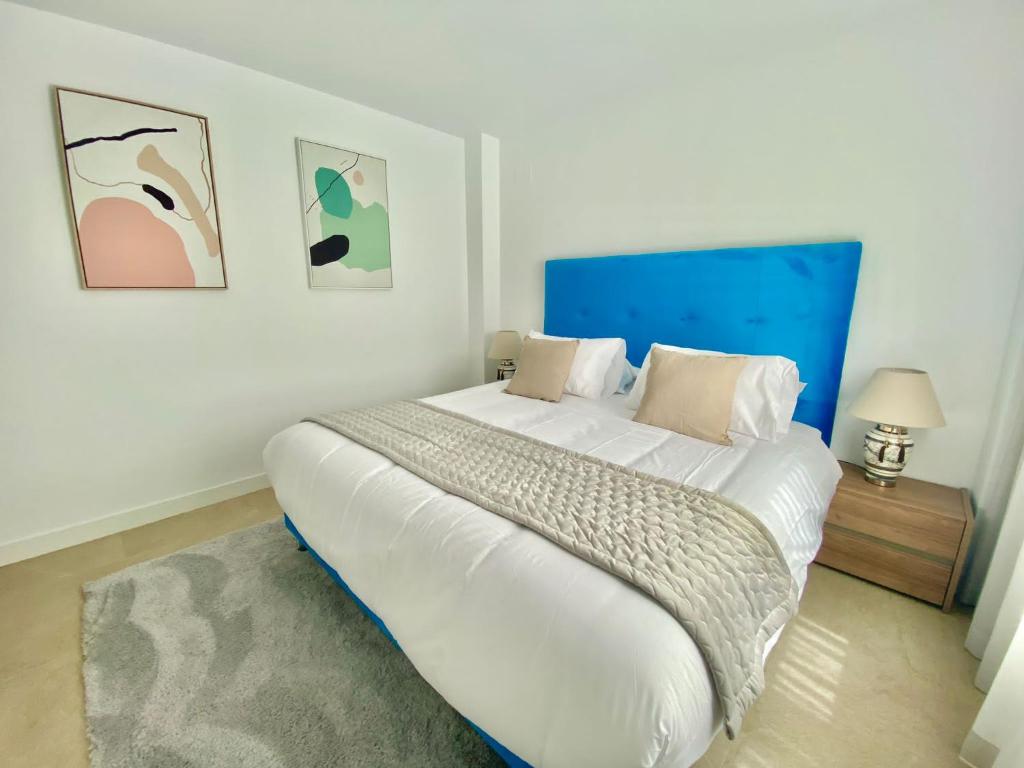 La MairenaLa Cala Golf - Luxury 3bed apartment - First line golf view的一间卧室配有一张白色大床和蓝色床头板