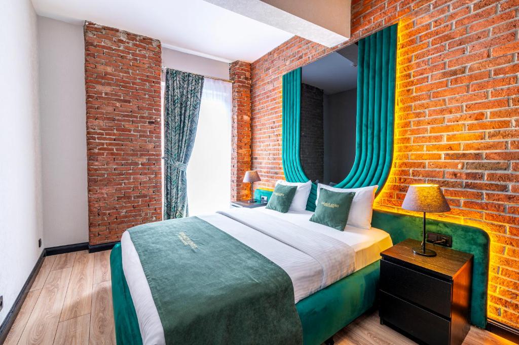 伊斯坦布尔卡拉克雷住宿加早餐旅馆 - 特殊类别的一间卧室设有一张床和砖墙