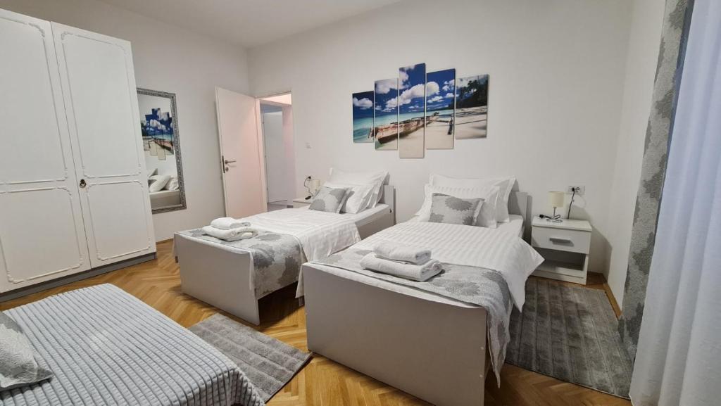 里耶卡Apartman Magnolija的白色的客房配有两张床和一张桌子