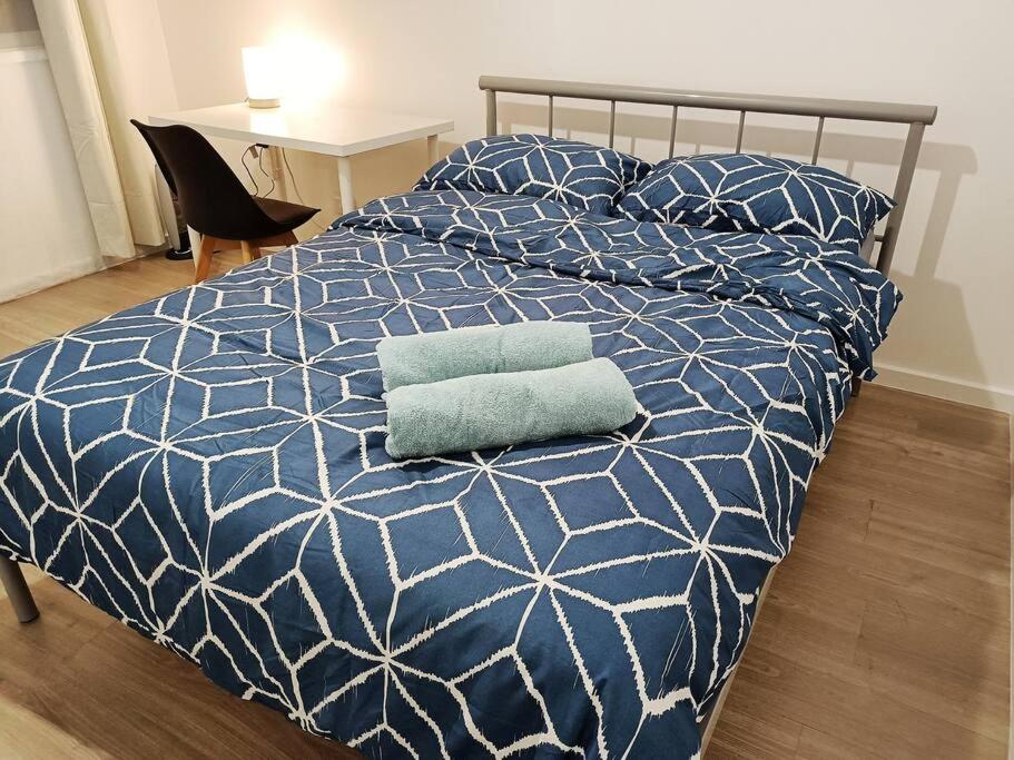 墨尔本PROMO 2-Bedroom Villa Next to Train Station, FREE PARKING的一张带蓝色和白色棉被和枕头的床