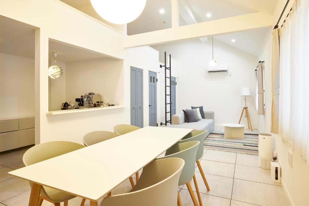 藤泽COFFEE HOTEL Soundwave的一间设有白色桌椅的用餐室