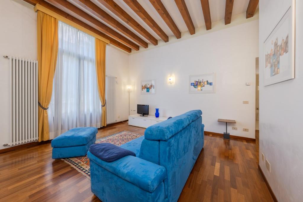 威尼斯科堤诺瓦酒店的客厅配有蓝色的沙发和两把椅子