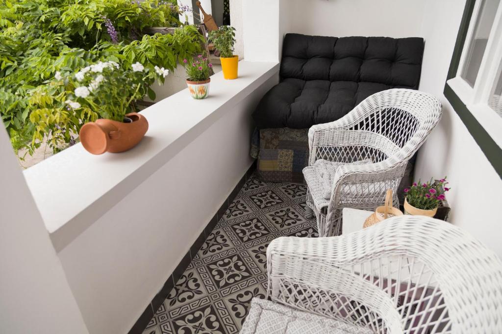 沙罗什保陶克Kurucz Apartman的阳台配有藤椅和沙发