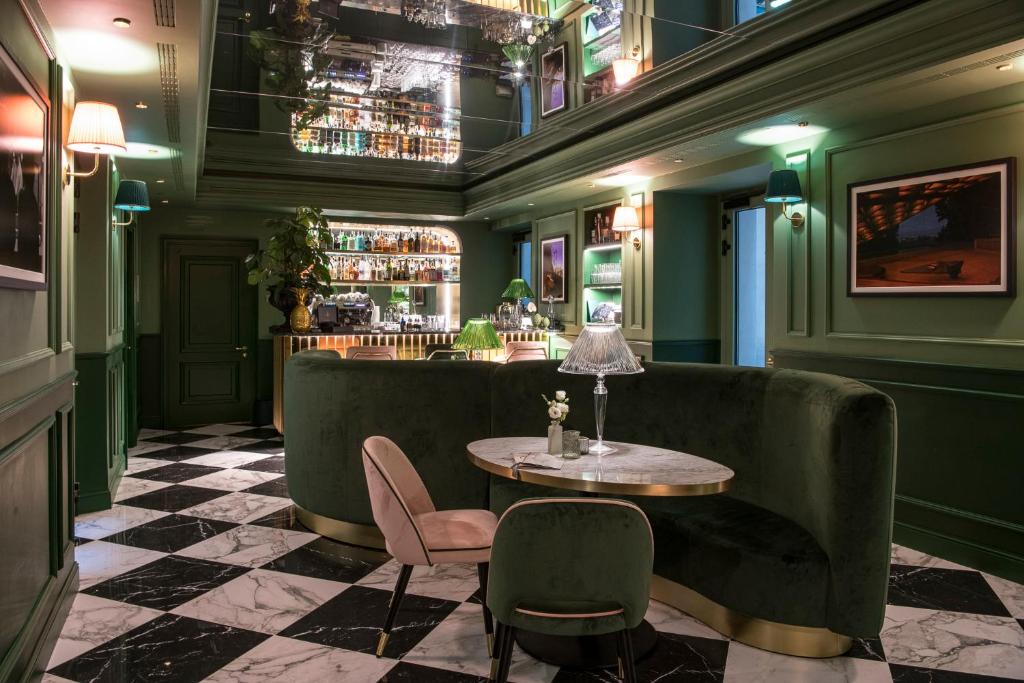 佛罗伦萨Hotel La Gemma的一间酒吧,拥有绿色的墙壁和桌椅