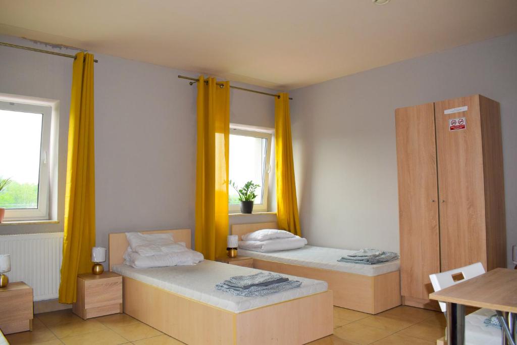 热舒夫Noclegi Rzeszów的配有黄色窗帘的客房内的两张床