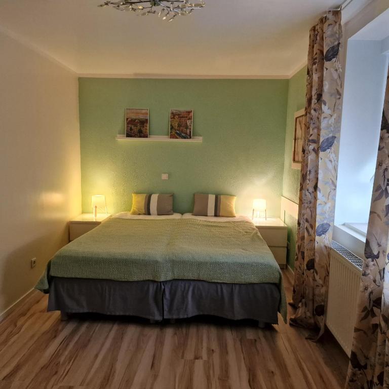 措森Rema Ferienwohnungen的一间设有床铺的卧室,位于一个拥有绿色墙壁的房间