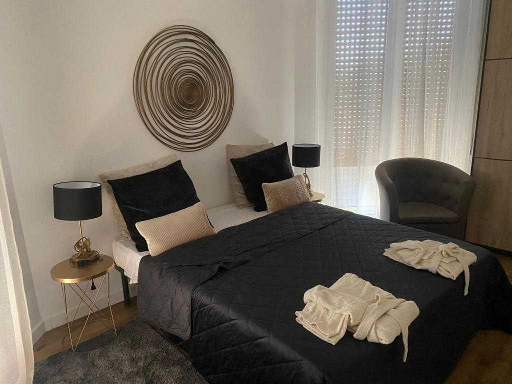 罗马Eur Centro lux apartment con camino的一间卧室配有一张黑色大床和一把椅子