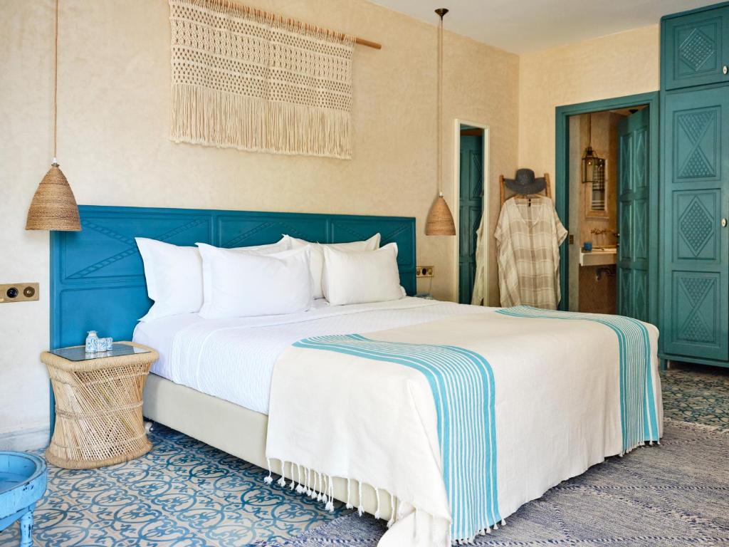 舍夫沙万Dar Jasmine的一间卧室配有一张大床和蓝色床头板
