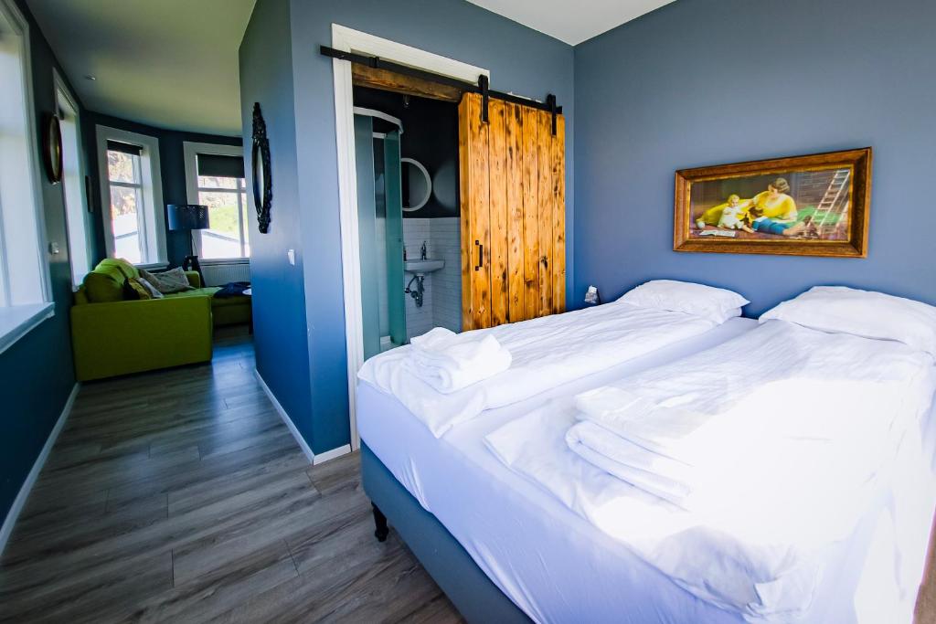 韦斯特曼纳埃亚尔Guesthouse Holl的一间卧室设有一张蓝色墙壁的大床