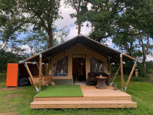 BeverstedtIQBAL Hütte - Luxus Zelt, Whirlpool extra的黑色帐篷,在田野上设有木门廊