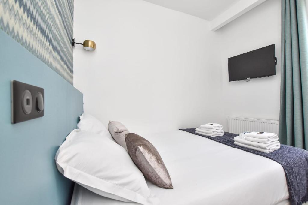 巴黎Résidence Beaugrenelle - Tour Eiffel 1的一间卧室配有带白色床单和枕头的床。