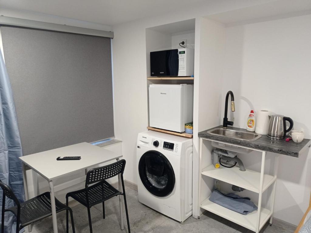 维尔纽斯Apartment hotels parking akaciju1的洗衣房配有洗衣机和桌子