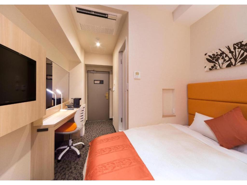千岁QUEEN'S HOTEL CHITOSE - Vacation STAY 67720v的酒店客房配有一张床、一张书桌和一台电视。