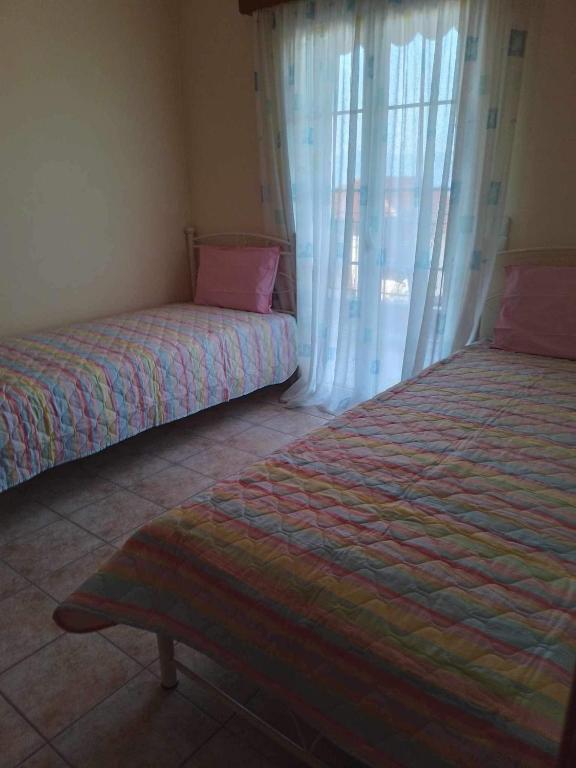 凯法利尼亚岛Kali’s comfort的一间卧室设有两张床和窗户。