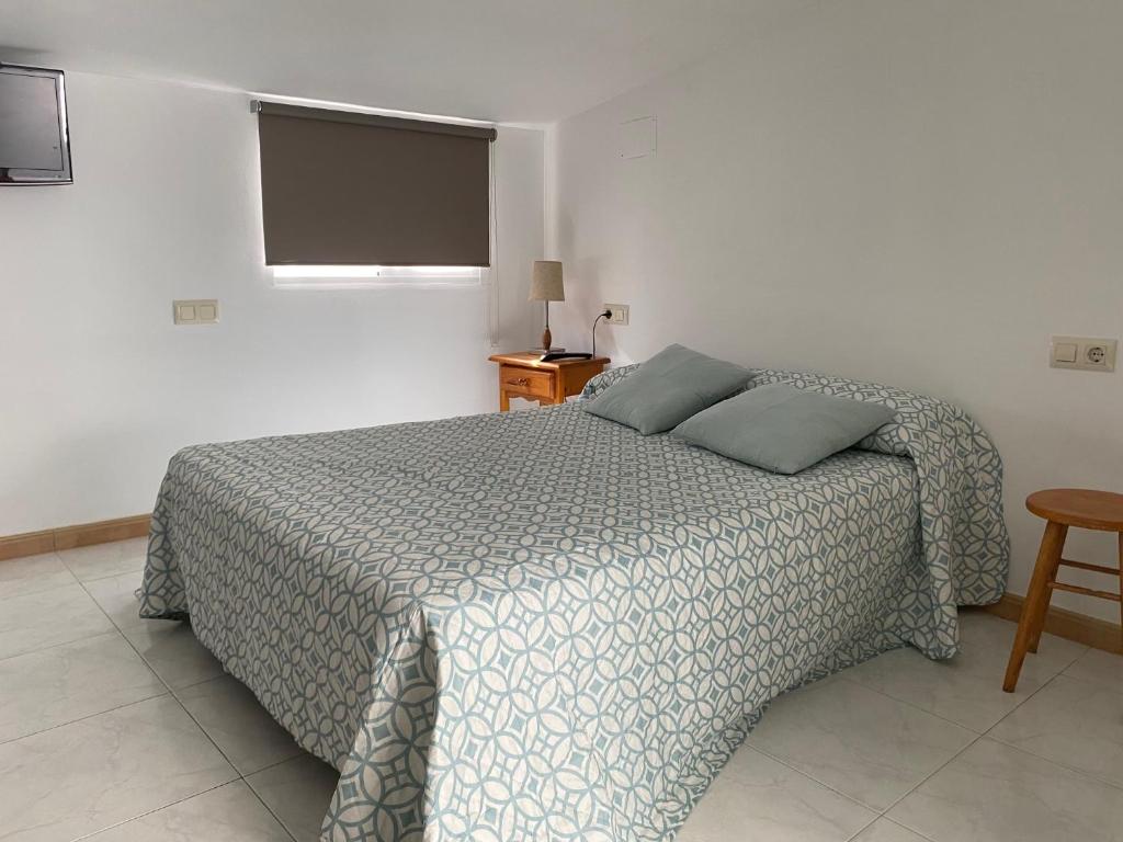卡尔达斯·德·雷斯Apartamentos OLIVA的一间卧室配有一张床和一台平面电视