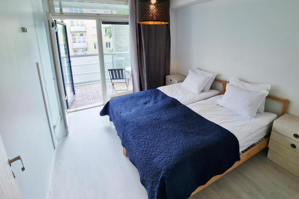 赫尔辛基Idas AirBnB的一间卧室配有一张带蓝色毯子的床和窗户。