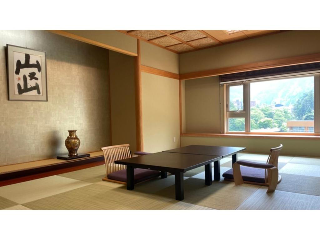 黑部市Unazuki Onsen Sanyanagitei - Vacation STAY 06557v的一间带桌子和两把椅子的用餐室以及窗户。