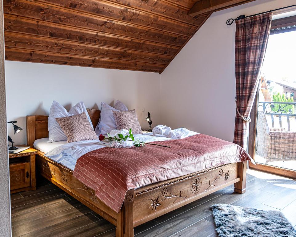 韦尔卡鲁穆尼卡Goralská Vila Lomnica的一间卧室设有一张大木床和窗户