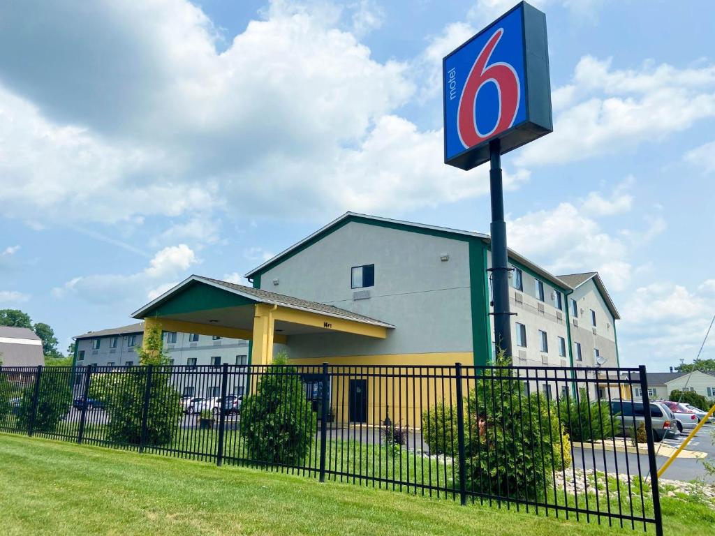 兰开斯特Motel 6 Lancaster的建筑物前有标志的加油站