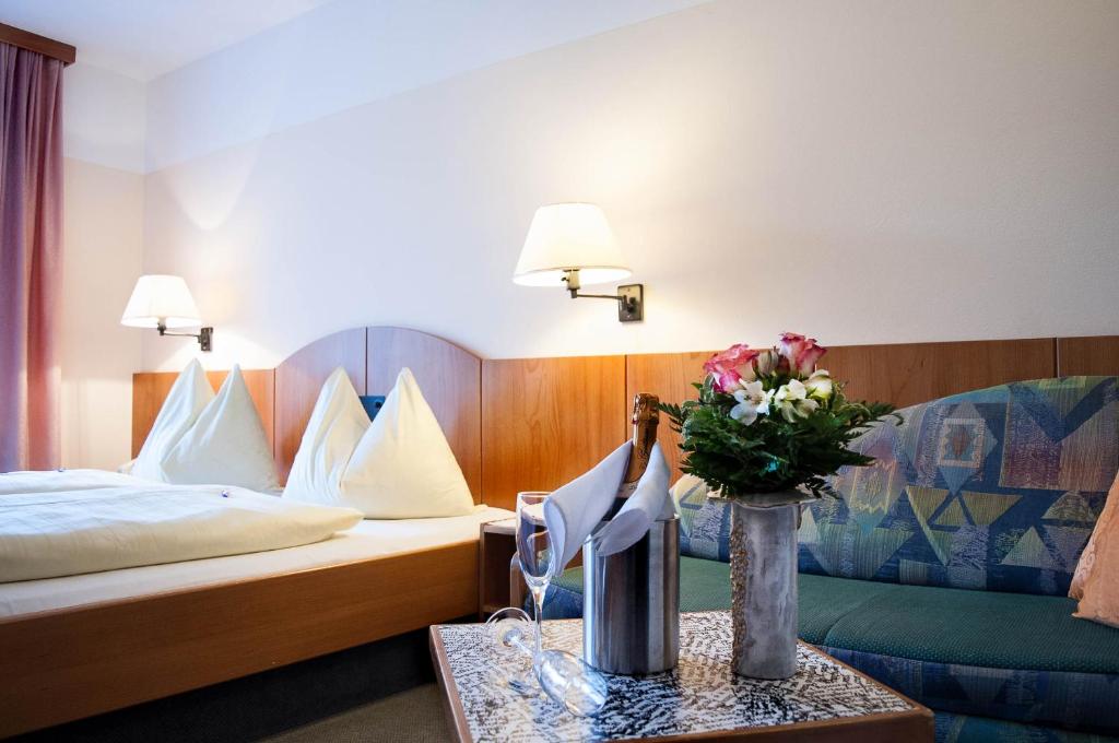斯皮特安德劳Hotel Edlingerwirt - Sauna & Golfsimulator inklusive的配有床和鲜花桌的酒店客房