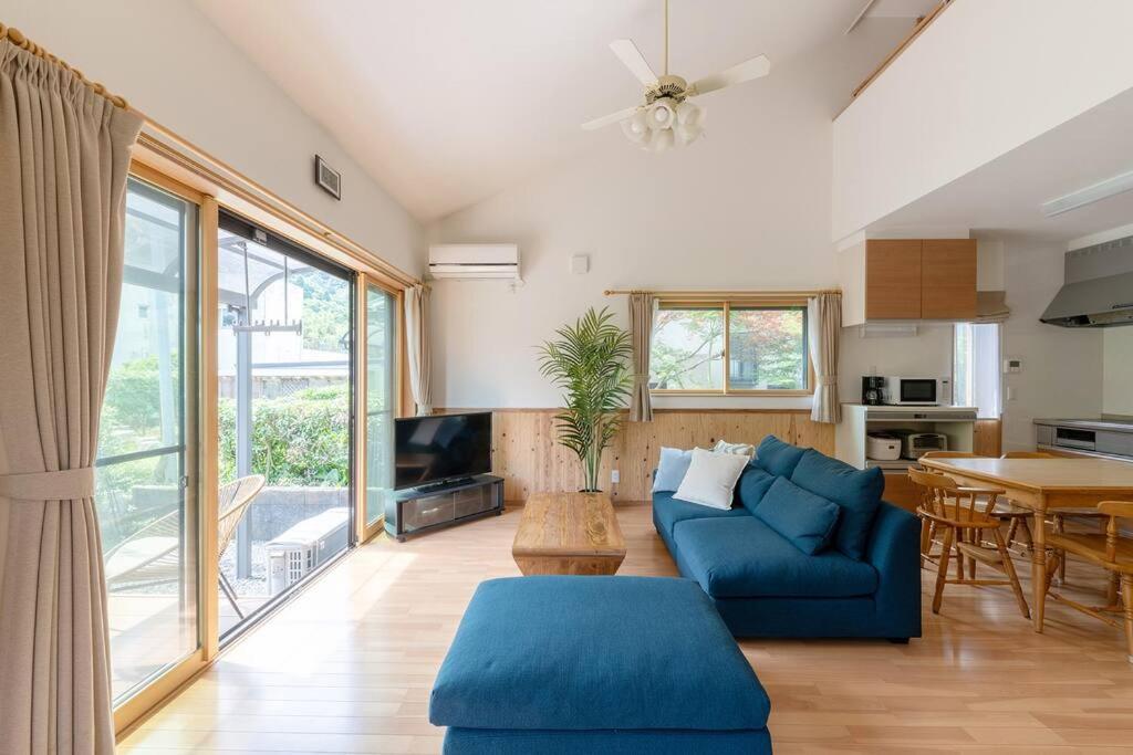 舞鹤市Seaside Villa Nagi的客厅配有蓝色的沙发和桌子