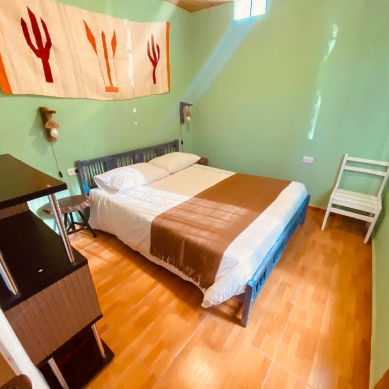 圣佩德罗·德·阿塔卡马Casa TAQI的卧室配有1张床、1张桌子和1把椅子