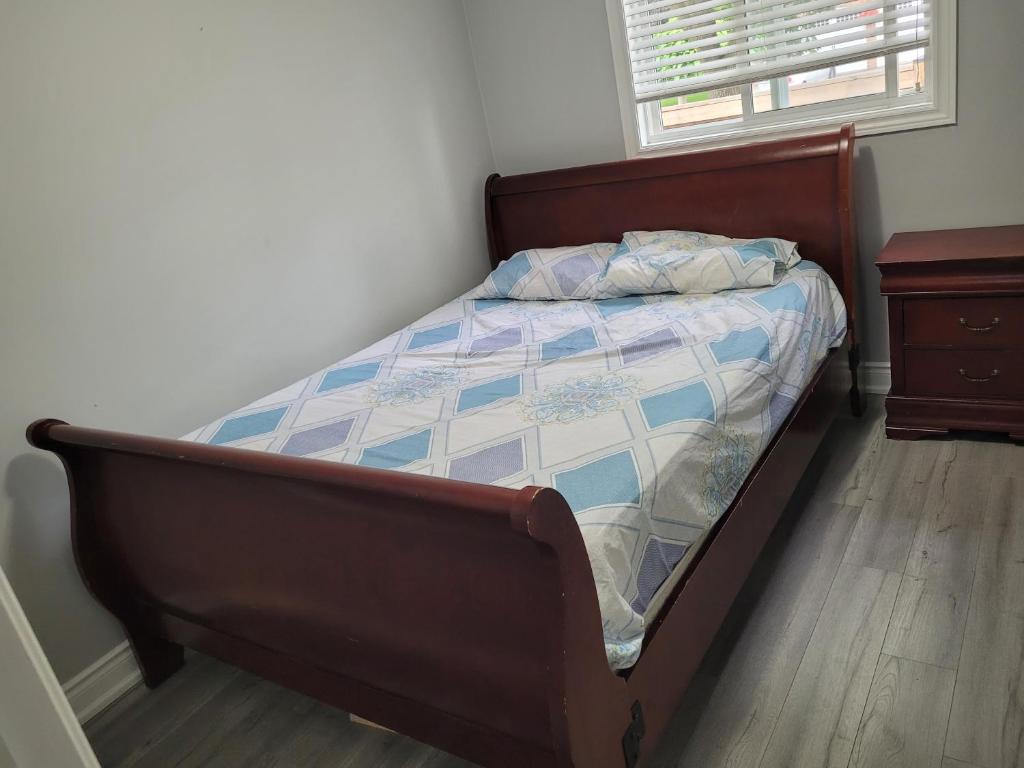 布兰普顿Individual home的卧室内的一张床位,铺有木地板