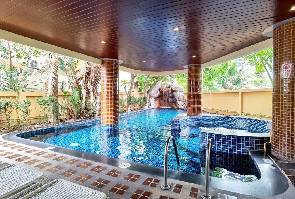 芭堤雅市中心Nova Gold Hotel Pattaya的一座房子里一个带瀑布的大型游泳池