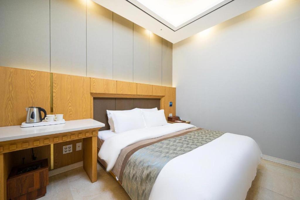 NajuHotel Core的酒店客房配有一张床、一张书桌和一张四柱床