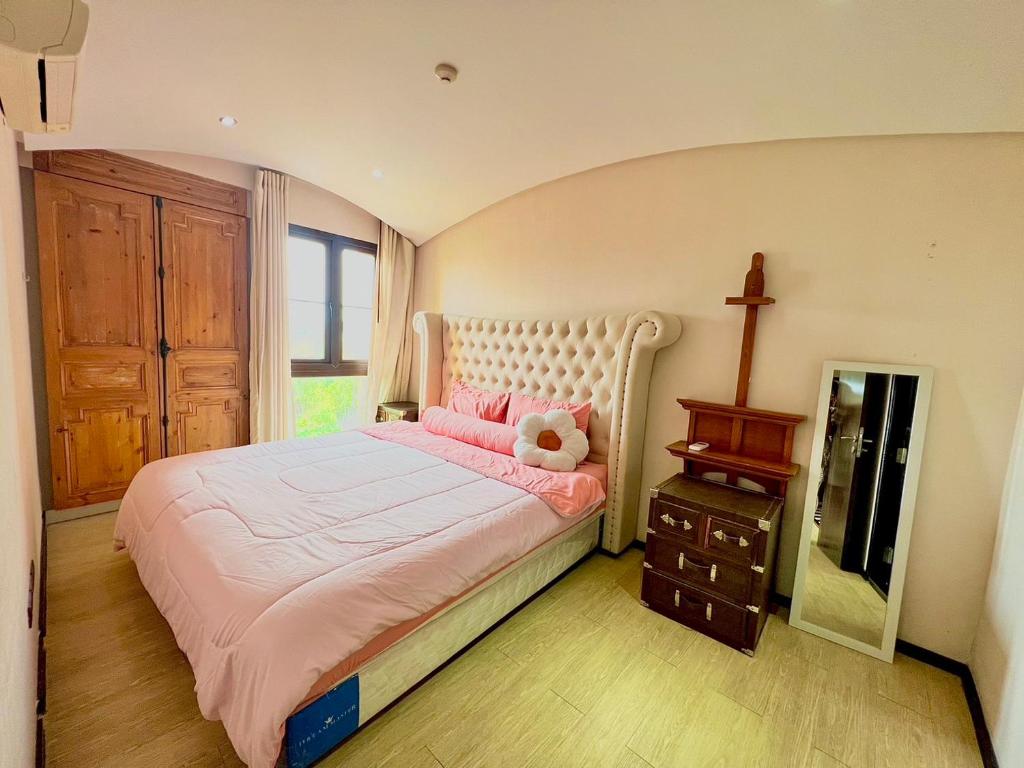 乔木提恩海滩Venetian river view的一间卧室配有粉红色的床,上面有泰迪熊